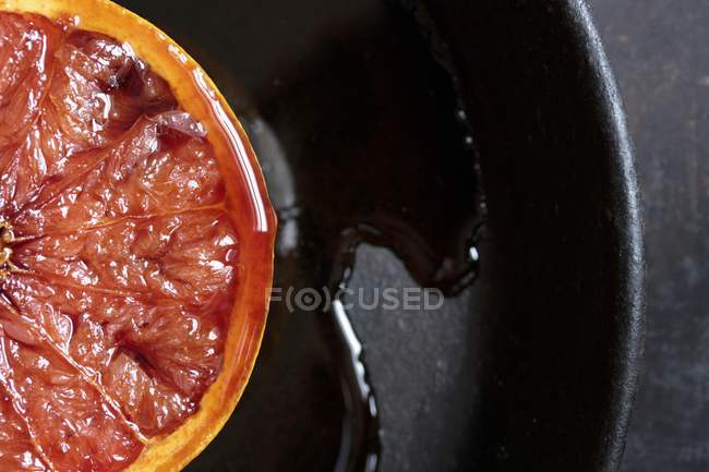 Gratinated grapefruit on black plate — Stock Photo