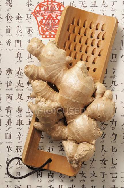 Fresh ginger root on wooden grater — Stock Photo