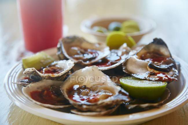 Oysters with spicy sauce — Stock Photo