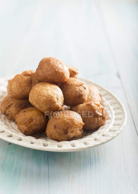Bunuelos - deep-fried pastries on white plate — Stock Photo