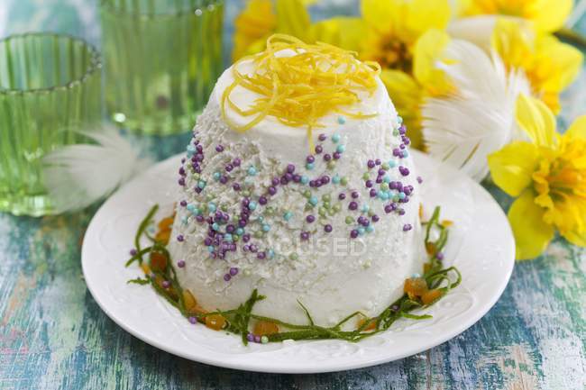 Cheesecake being decorated with sugar sprinkles — Stock Photo
