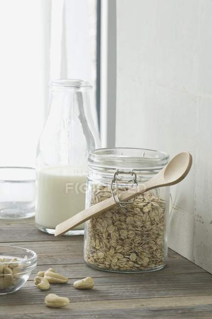 Hafer in Aufbewahrungsgefäß und Flasche Milch — Stockfoto