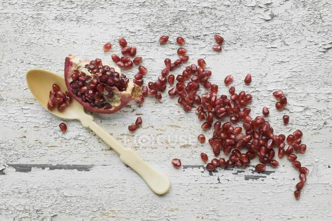 Cuña de granada y semillas con cuchara - foto de stock