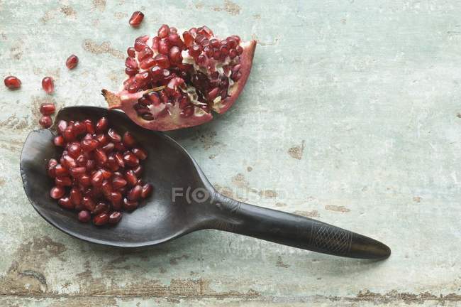 Pomegranate wedge and seeds with spoon — Stock Photo