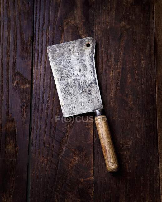 Vista superior de cerca de una cuchilla de carne antigua en una superficie de madera - foto de stock