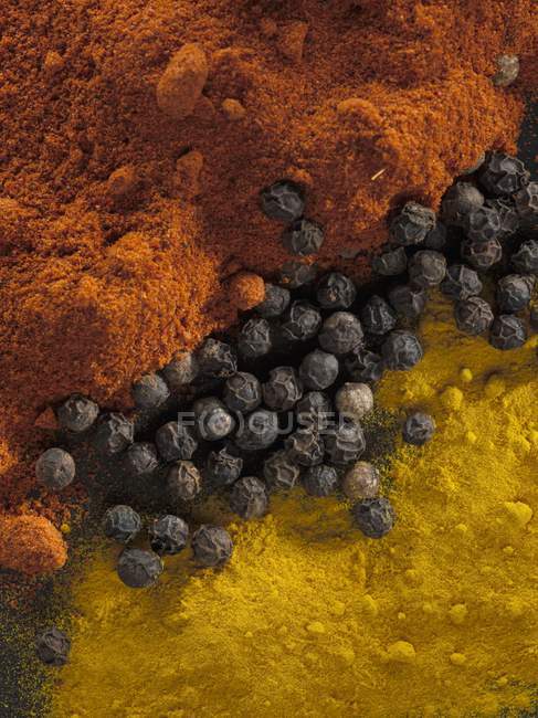 Closeup top view of pepper with chilli and curcuma powders — Stock Photo