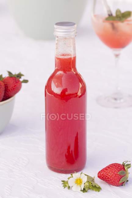 Vista de cerca de la botella de ruibarbo y jarabe de fresa - foto de stock