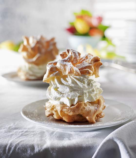 Closeup view of Profiterole with whipped cream and icing sugar — Stock Photo