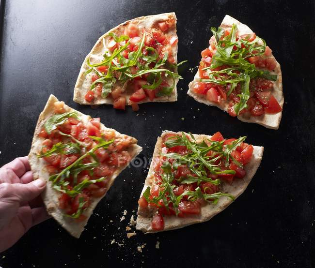 Hand nimmt ein Stück Pizza — Stockfoto