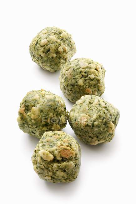 Closeup view of five spinach dumplings on white surface — Stock Photo