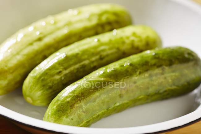 Semi-pickled cucumbers in bowl — Stock Photo