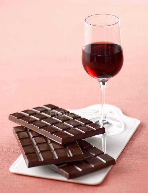 Red wine and stacked chocolate bars — Stock Photo