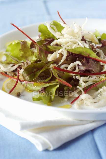 Salad with young fried fish on plate — Stock Photo