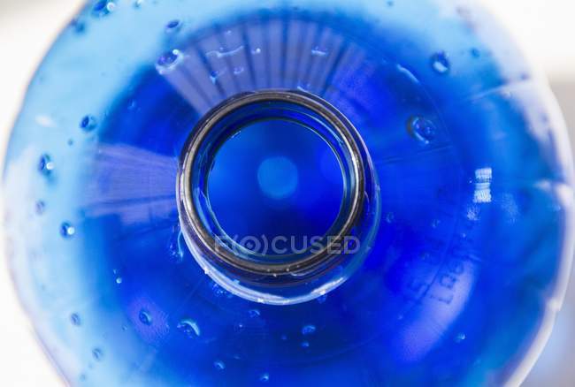 Primer plano vista superior de la botella azul de agua - foto de stock