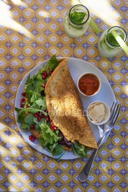 Top view of omelette with rocket and pomegranate seeds — Stock Photo
