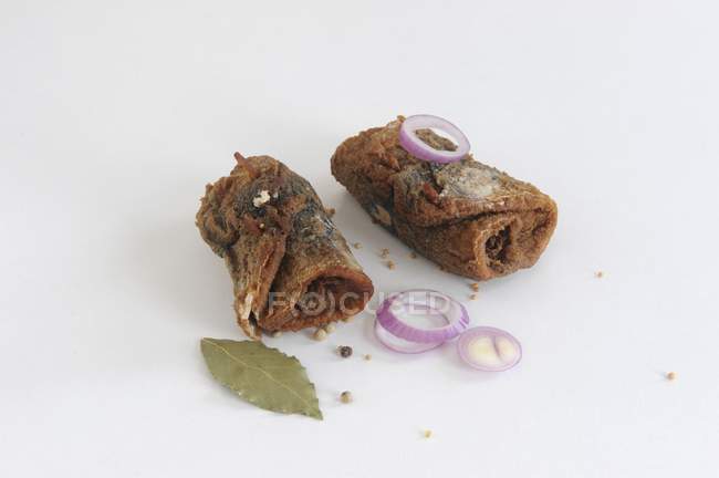 Closeup view of fried rollmop herring with onion rings — Stock Photo