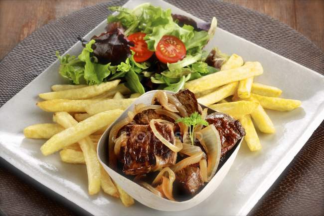 Salada e batatas fritas no prato — Fotografia de Stock