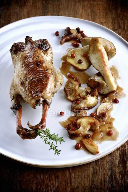 Quail with mushrooms and pears  over white plate — Stock Photo