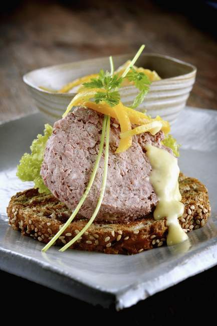 Closeup view of toast topped with duck pate, herbs and lemon peels — Stock Photo
