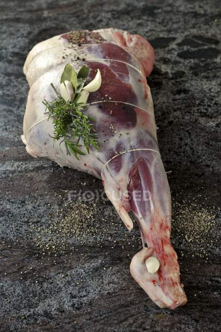 Raw leg of lamb with herbs and spices — Stock Photo