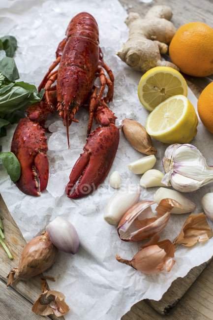 Приготовлені омари та різні інгредієнти на шматочку паперу — стокове фото