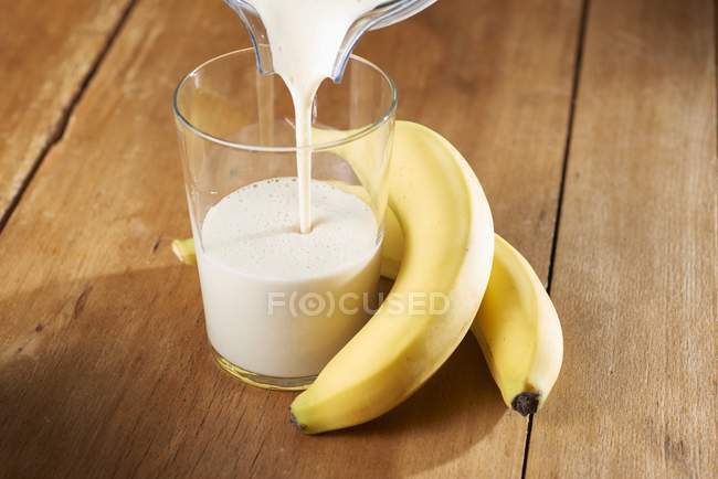 Banana smoothie and fresh bananas — Stock Photo