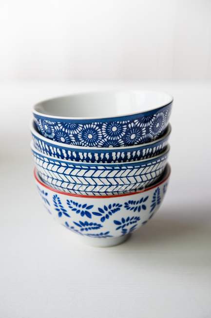 Closeup view of four blue and white patterned bowls on a white surface — Stock Photo
