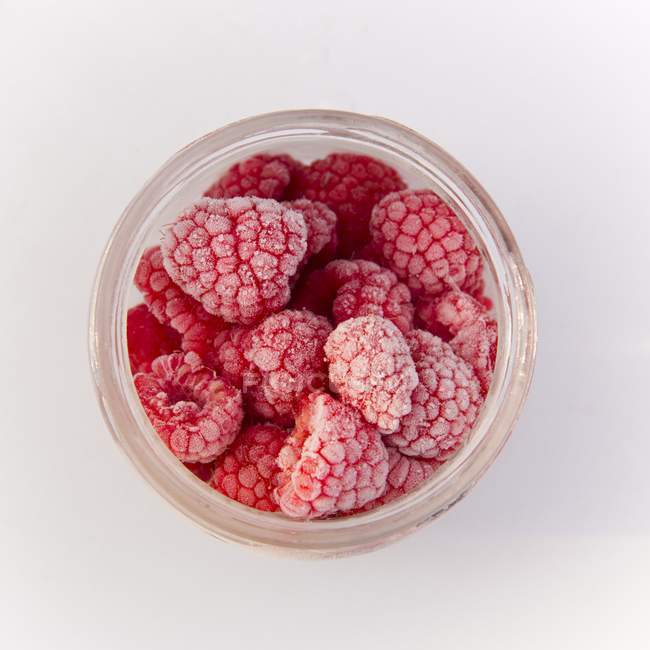 Jar of red frozen raspberries — Stock Photo