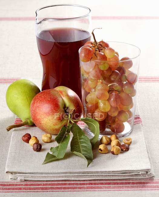 Vista de perto de frutas frescas, avelãs e vinho tinto na toalha — Fotografia de Stock