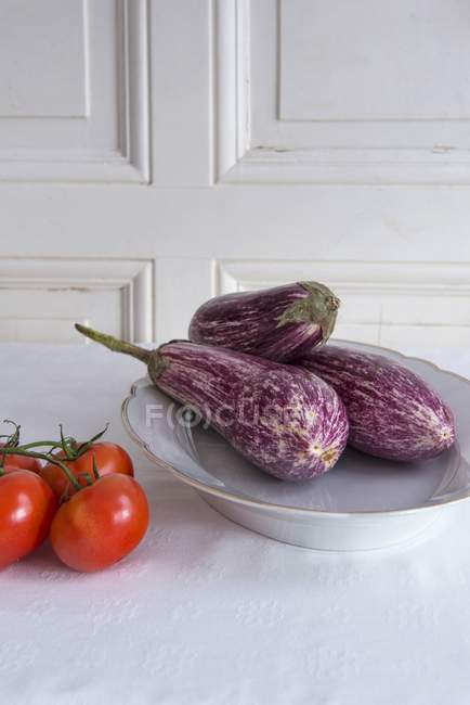 Баклажаны на фарфоровой тарелке — стоковое фото