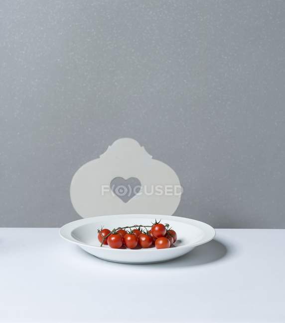 Vine tomatoes on plate — Stock Photo