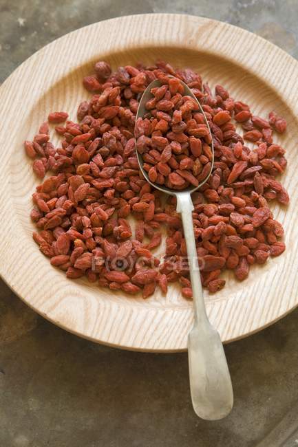 Dried Goji berries on wooden plate — Stock Photo