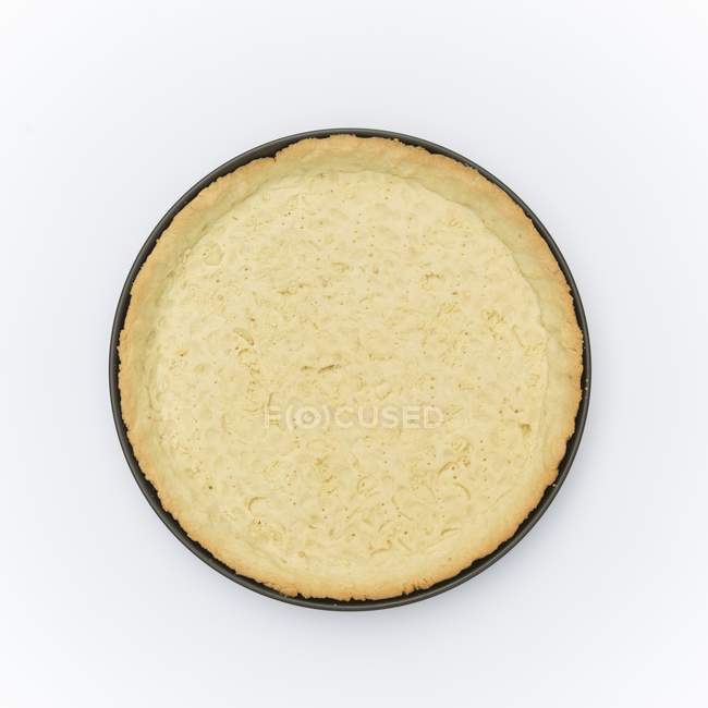Top view of pastry base in tart tin on white surface — Stock Photo