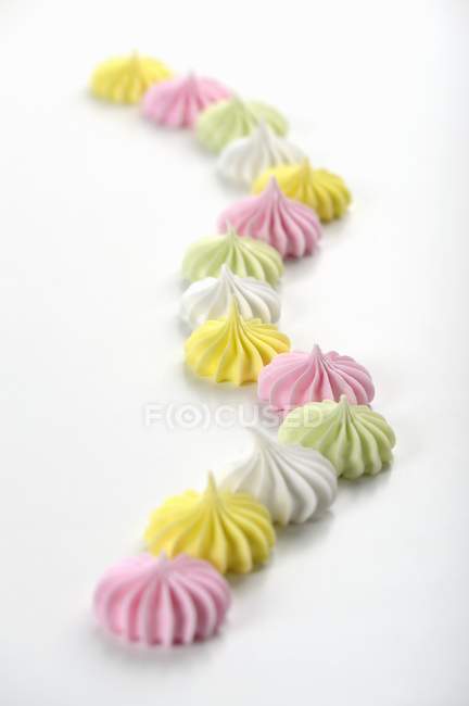 Merengues coloridos em uma superfície branca — Fotografia de Stock