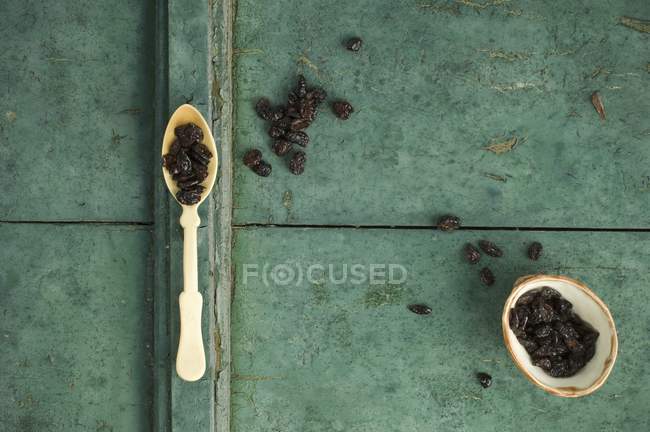 Arándanos secos en cuchara y en tazón - foto de stock