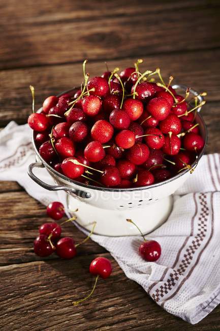 Fresh ripe Cherries in colander — Stock Photo
