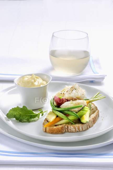 Stock fish with aioli on grilled bread — Stock Photo