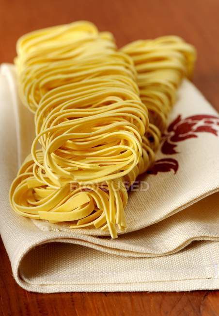 Dry uncooked tagliatelle pasta — Stock Photo