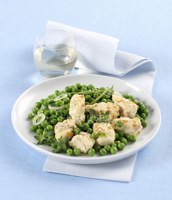 Closeup view of monkfish with green peas and herbs — Stock Photo