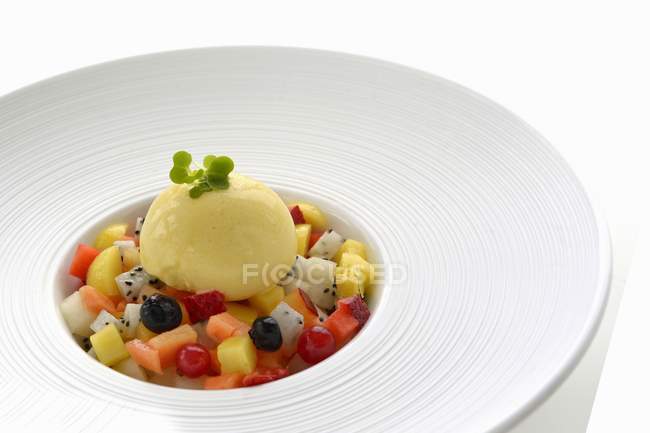 Cucharada de helado de vainilla en una ensalada de frutas - foto de stock