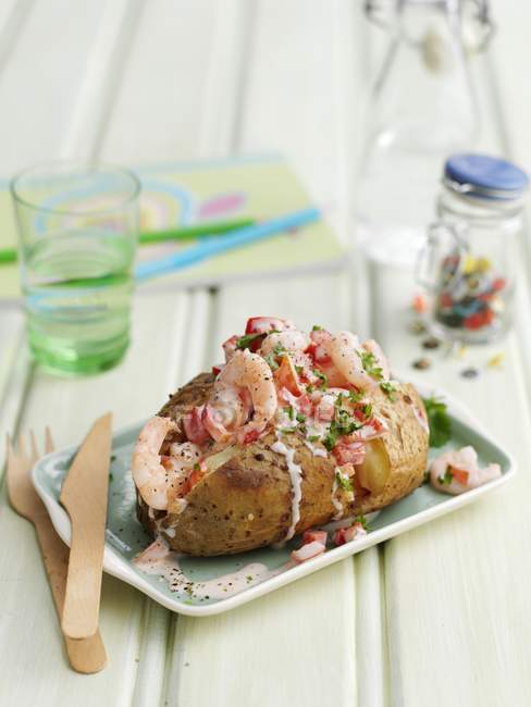 Quick jacket potato with prawns on small plate over table — Stock Photo