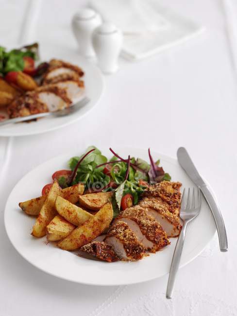 Pedaços de frango com batatas e saladas — Fotografia de Stock