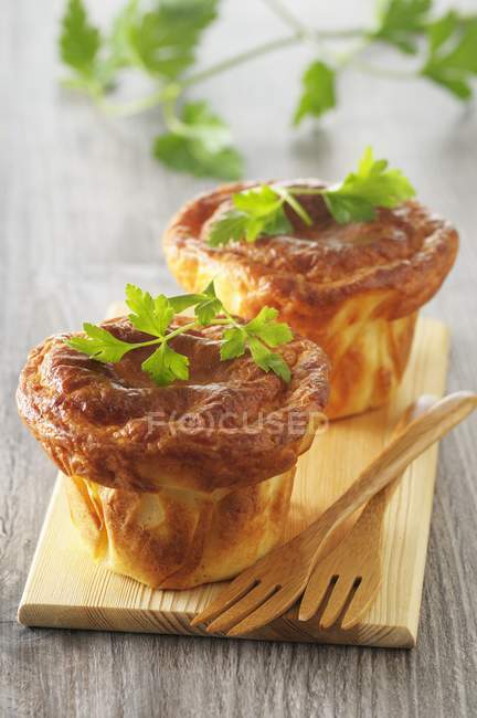 Closeup view of souffles with parsley and wooden forks on board — Stock Photo