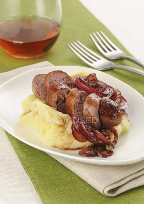 Salamelle alla grappa e pur - Grappa sausages with mashed potatoes on white plate over towel — Stock Photo