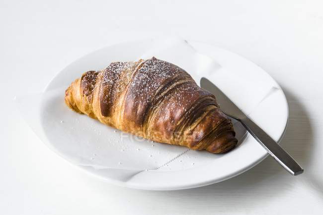 Croissant auf weißem Teller — Stockfoto