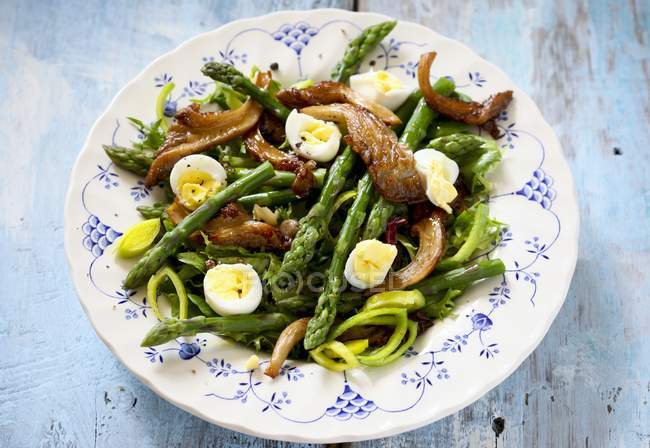 Green asparagus with fried oyster mushrooms and quail eggs — Stock Photo