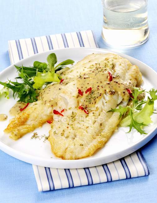 Cod fillet with herbs and mustard sauce — Stock Photo