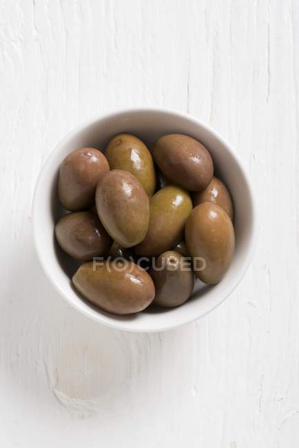 Olives vertes marinées dans un bol blanc — Photo de stock