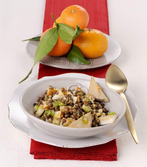 Winter lentil salad in bowl and oranges — Stock Photo