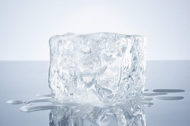 Vista de close-up de um bloco de gelo em uma superfície reflexiva — Fotografia de Stock